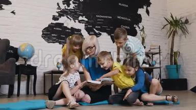 一群漂亮的孩子在<strong>幼儿园</strong>和<strong>幼儿园</strong>老师谈论书。 快乐的儿童日托工作者